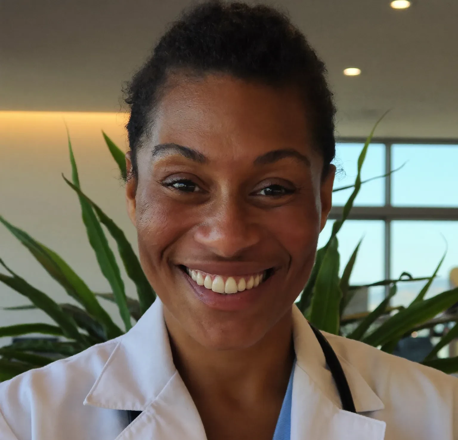 A warm, approachable physician in a naturally lit clinic